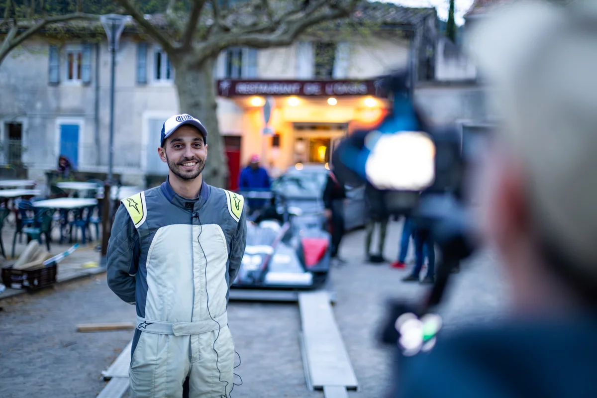 Tom Diebold équipé d’un micro devant une caméra dans le paddock